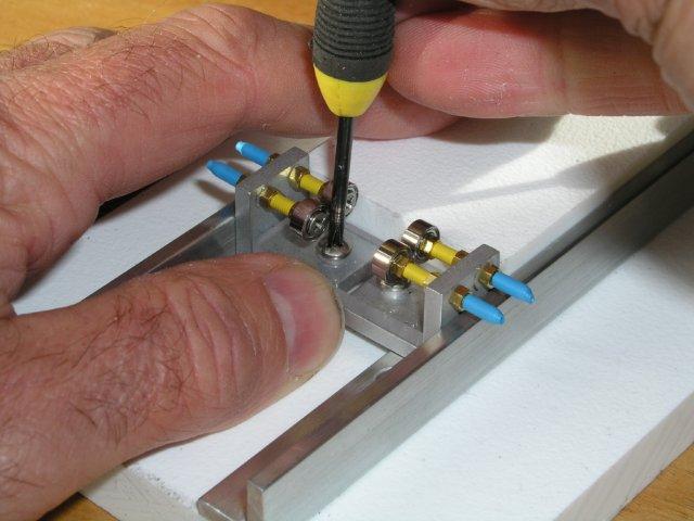 A finger will do, as you push the carriage up against the slider to true up carriage sides with base...